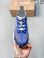Top view of one blue and white NORDA sneaker showing the laces, tongue, toe panels, and reflective-looking details.