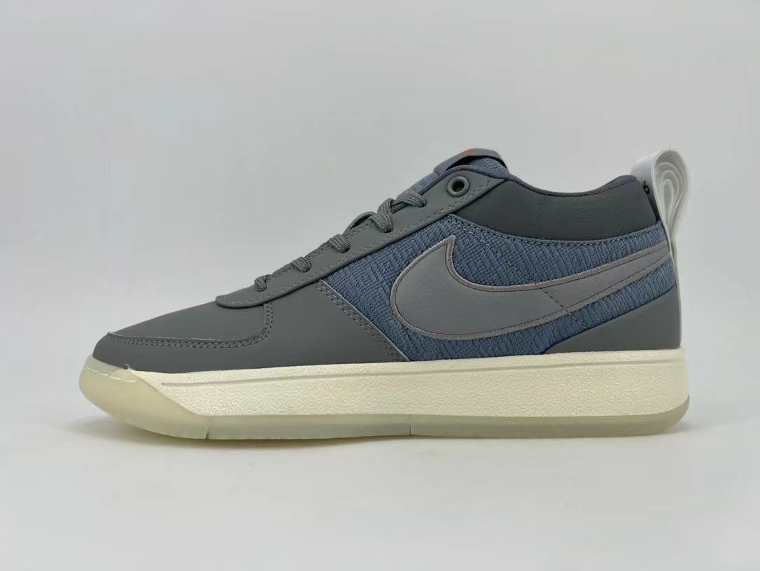 Side view of grey and blue low-top sneakers with a Swoosh and cream-colored sole.
