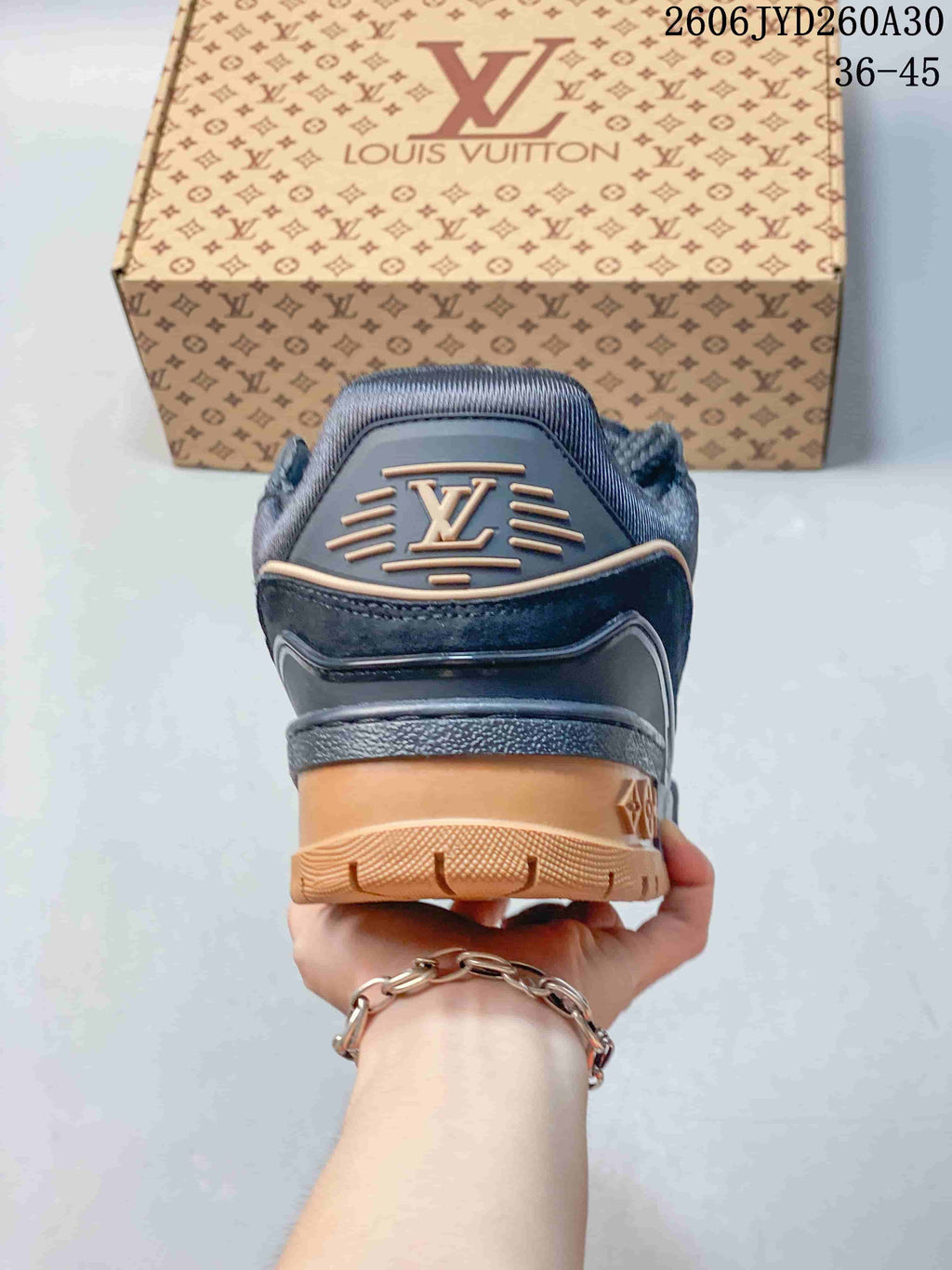 Rear view of the navy sneaker showing tan heel and outsole details