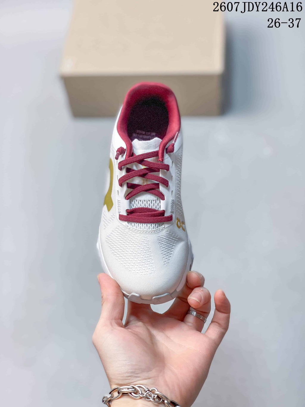 Top view of the white lace-up shoe showing the textured upper, burgundy laces, and burgundy padded collar.