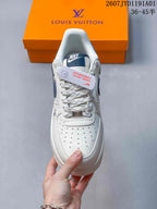 Front view of the sneaker showing a perforated toe, patterned laces, and navy tongue detail.