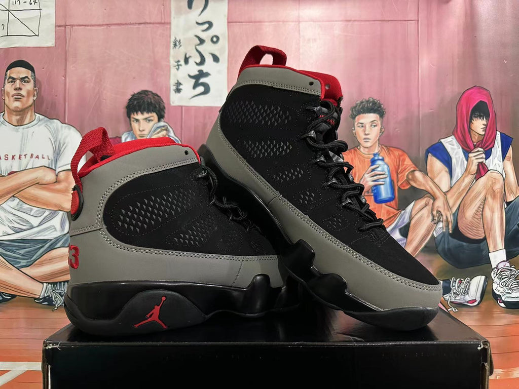 Pair of black and grey Jordan high-top sneakers with red accents, shown at an angle