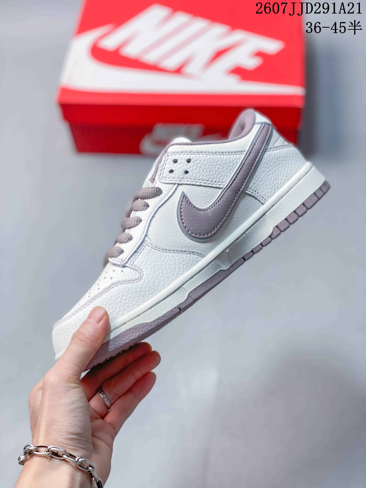 Side profile showing the white textured upper, gray Swoosh panel, perforated collar overlay, and contrasting outsole.