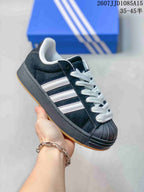 Angled side view highlighting the black upper, white stripe detailing, shell toe, and platform-style sole.