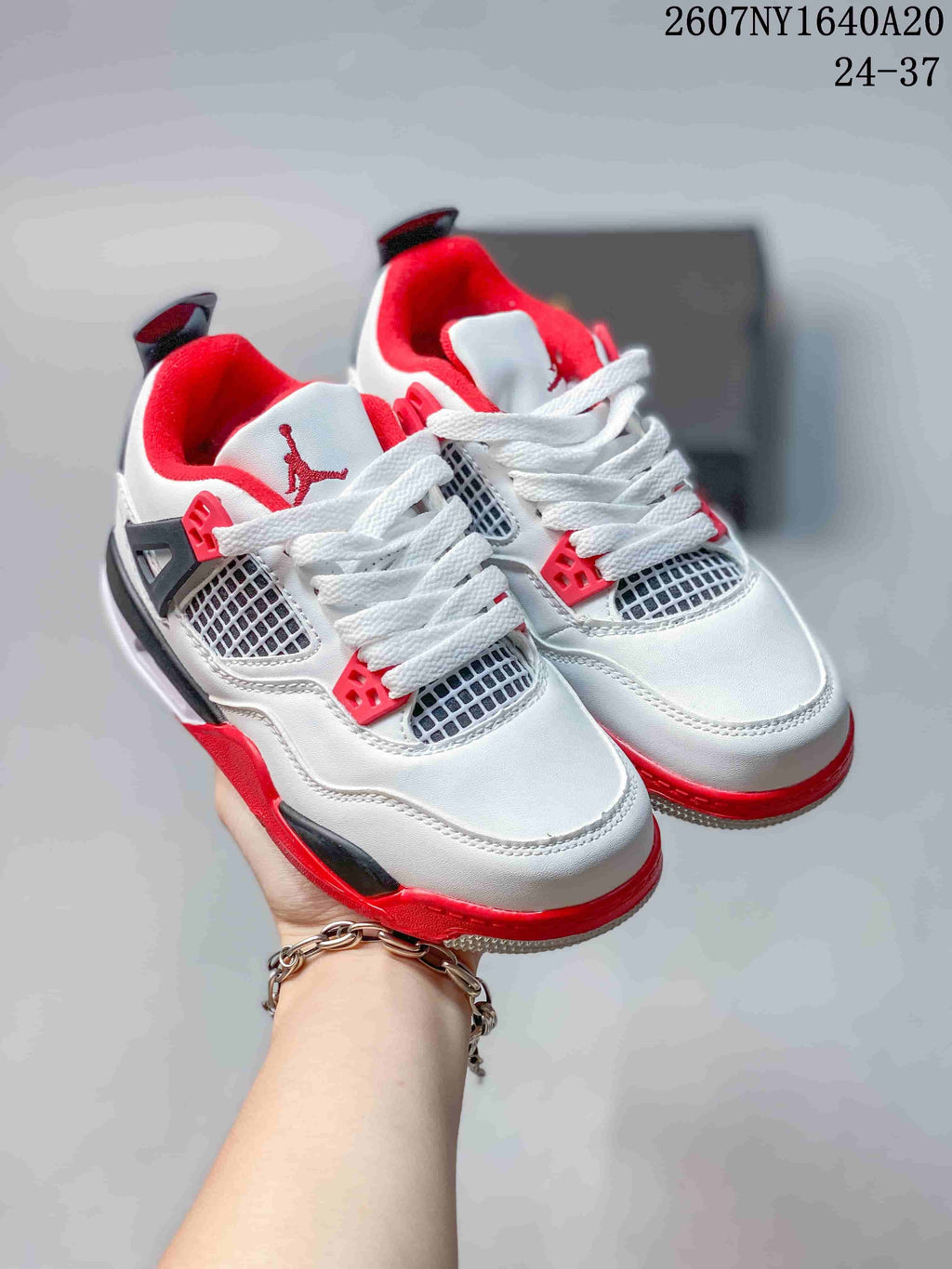 Pair of white Jordan children's sneakers with red and black accents, shown from an angled front view.