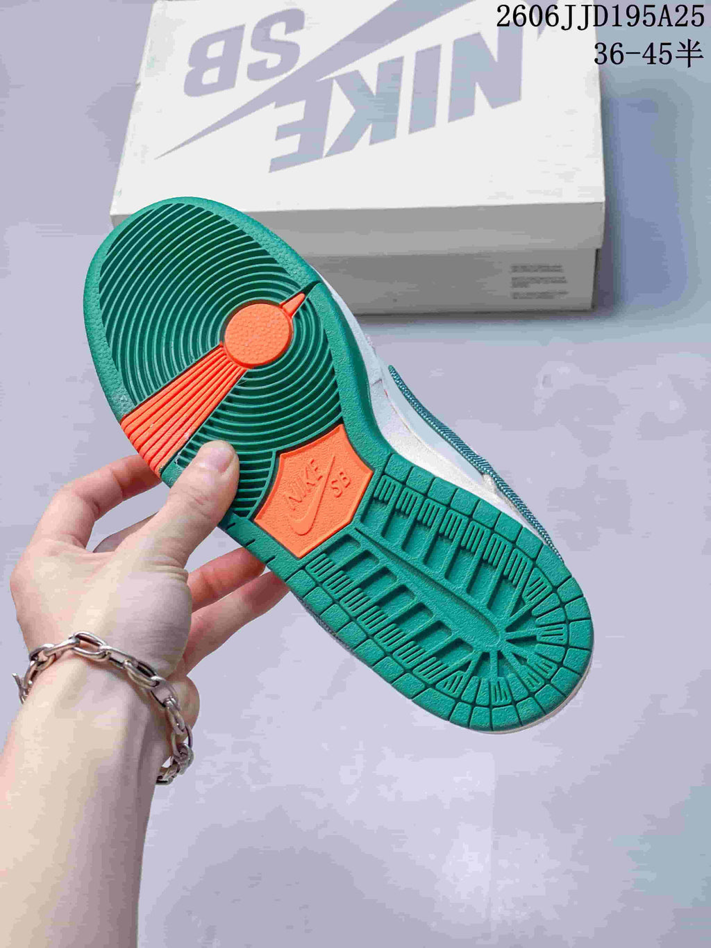 Underside view showing the textured green rubber outsole with orange traction sections and molded Nike SB details.