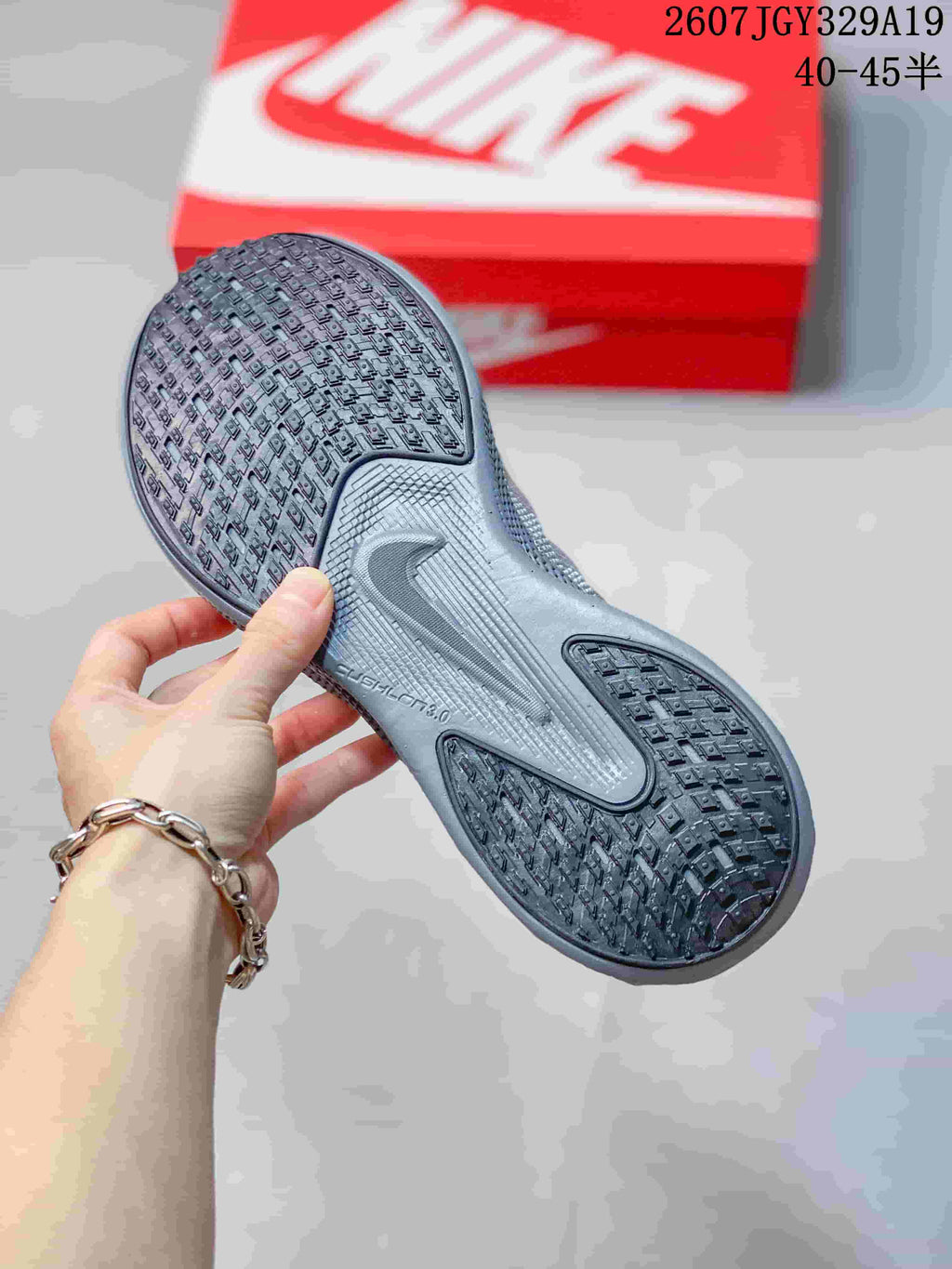 Close view of the sneaker outsole showing a dark textured tread pattern and central molded detailing.