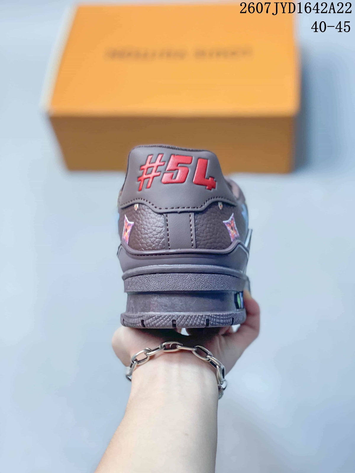 Rear view of the dark brown sneaker showing the padded heel collar and red number detailing; image text shows 2607 TYD1642A22 and 40–45.