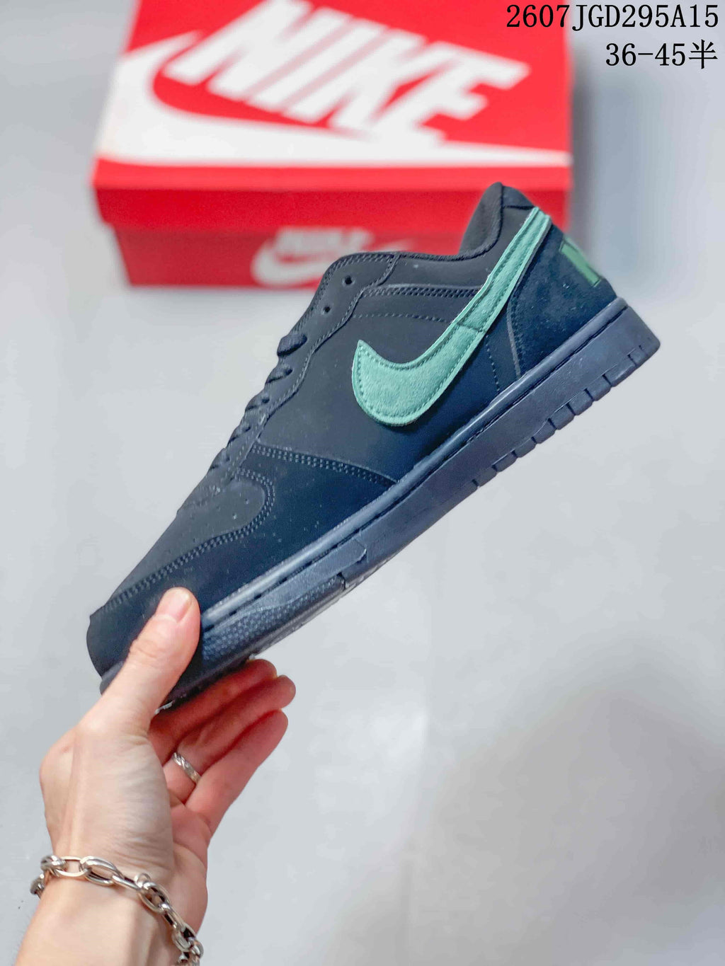 Side profile of the black low-top sneaker with a mint-green Swoosh, lace eyelets, stitched panels, and black sole.