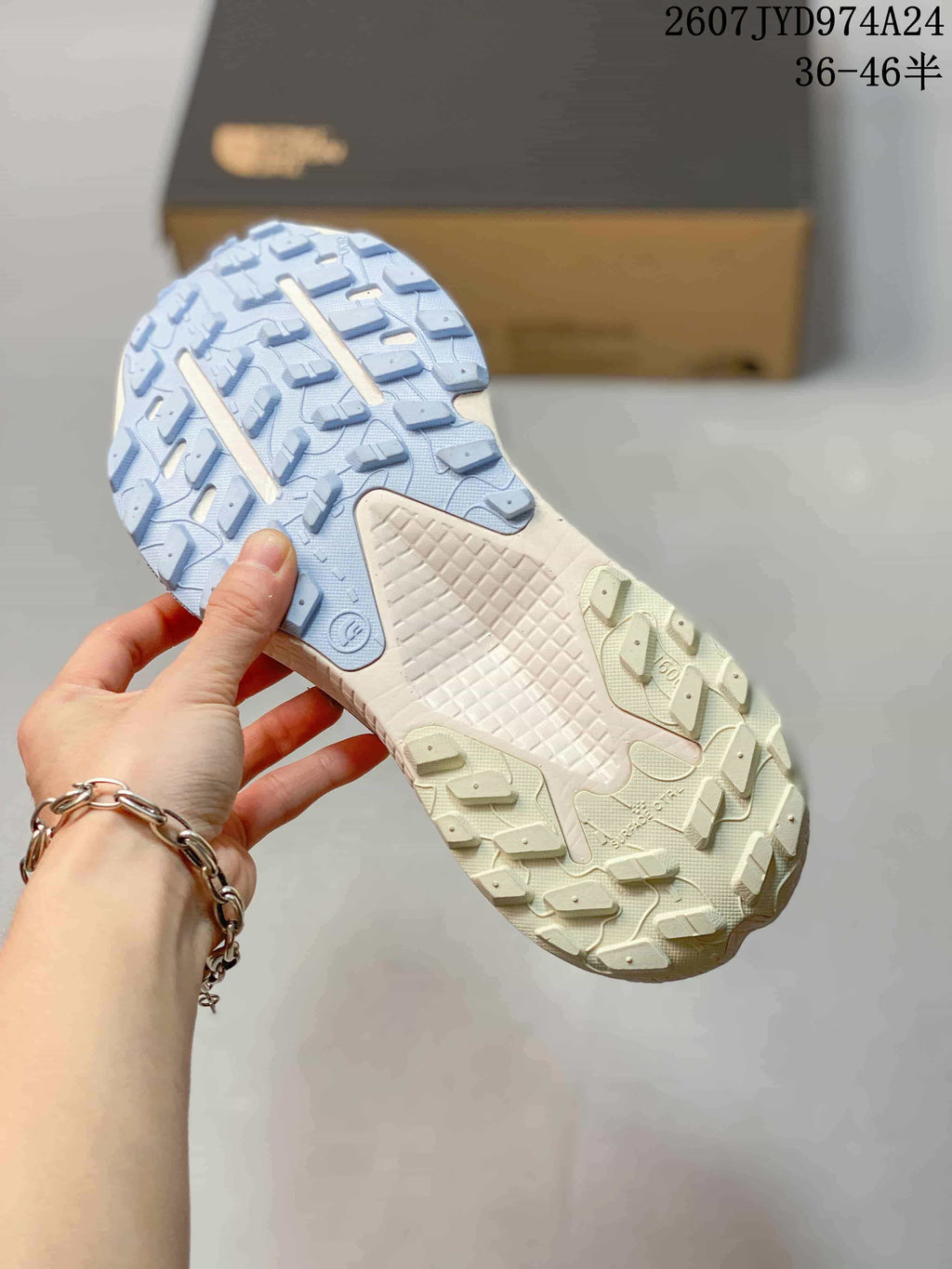 Close view of the patterned light blue and cream lugged outsole of the sneaker.
