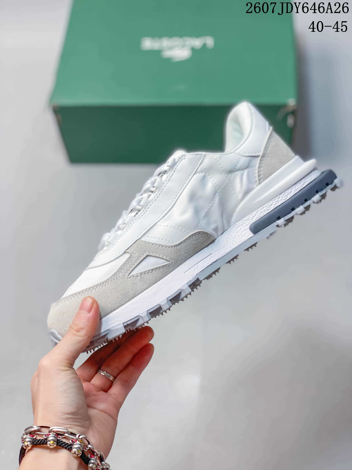 Side profile of the white and gray low-top sneaker showing the lace-up construction, layered panels, and lugged outsole.