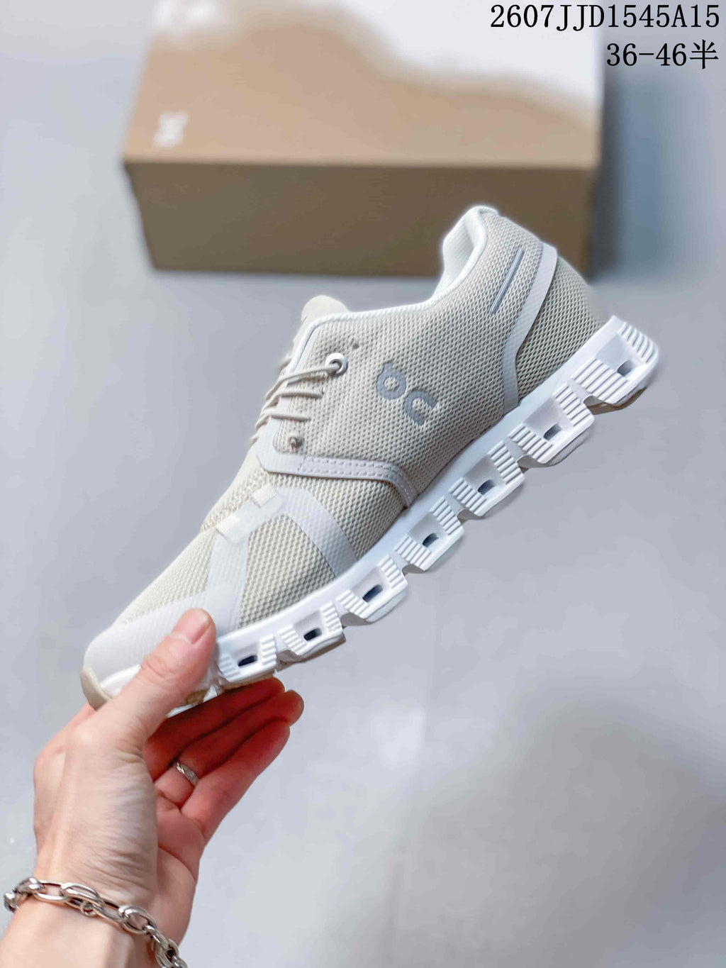 Side profile of a white and light gray On CloudTilt sneaker showing mesh panels, overlays, and the segmented sole.
