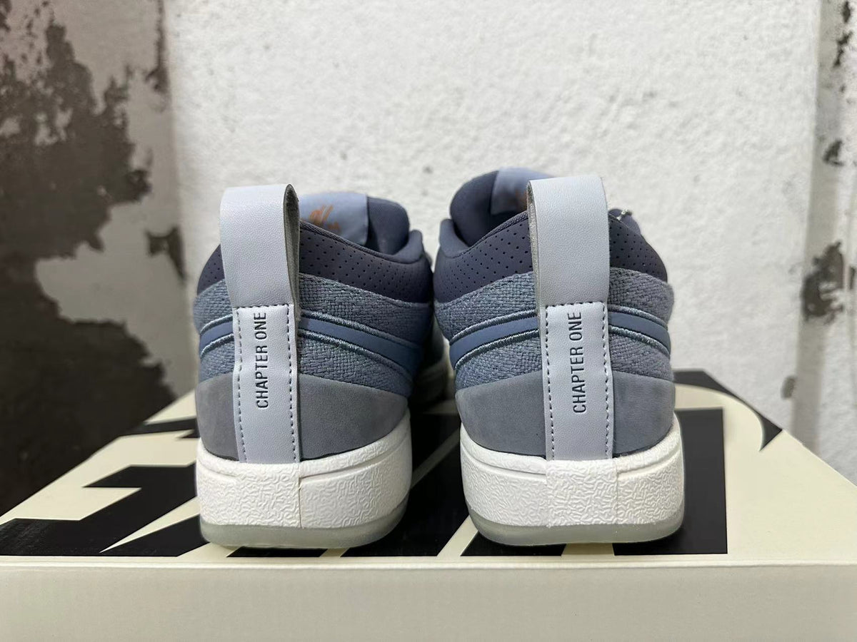 Rear view of blue-gray Nike Book 1 shoes showing heel pull tabs and layered heel panels