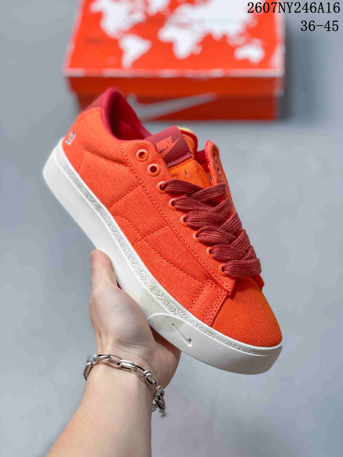 Angled side view of the orange Nike sneaker showing the low-top silhouette, stitched upper panels, and white outsole.