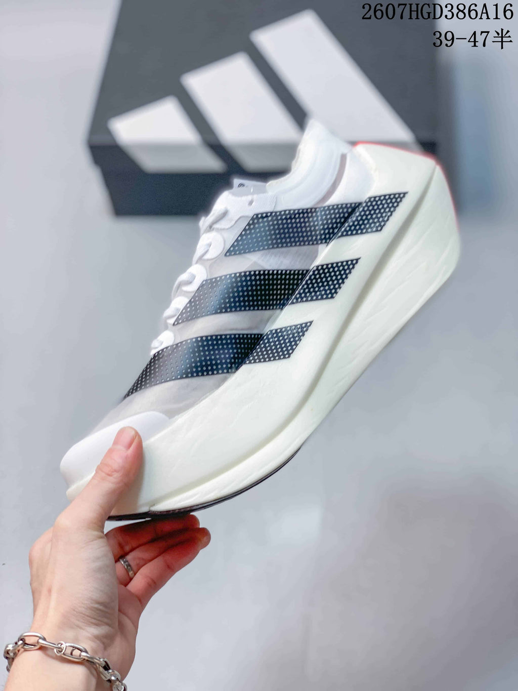 Side profile showing the white upper, black dotted stripe graphics, and thick sculpted midsole.