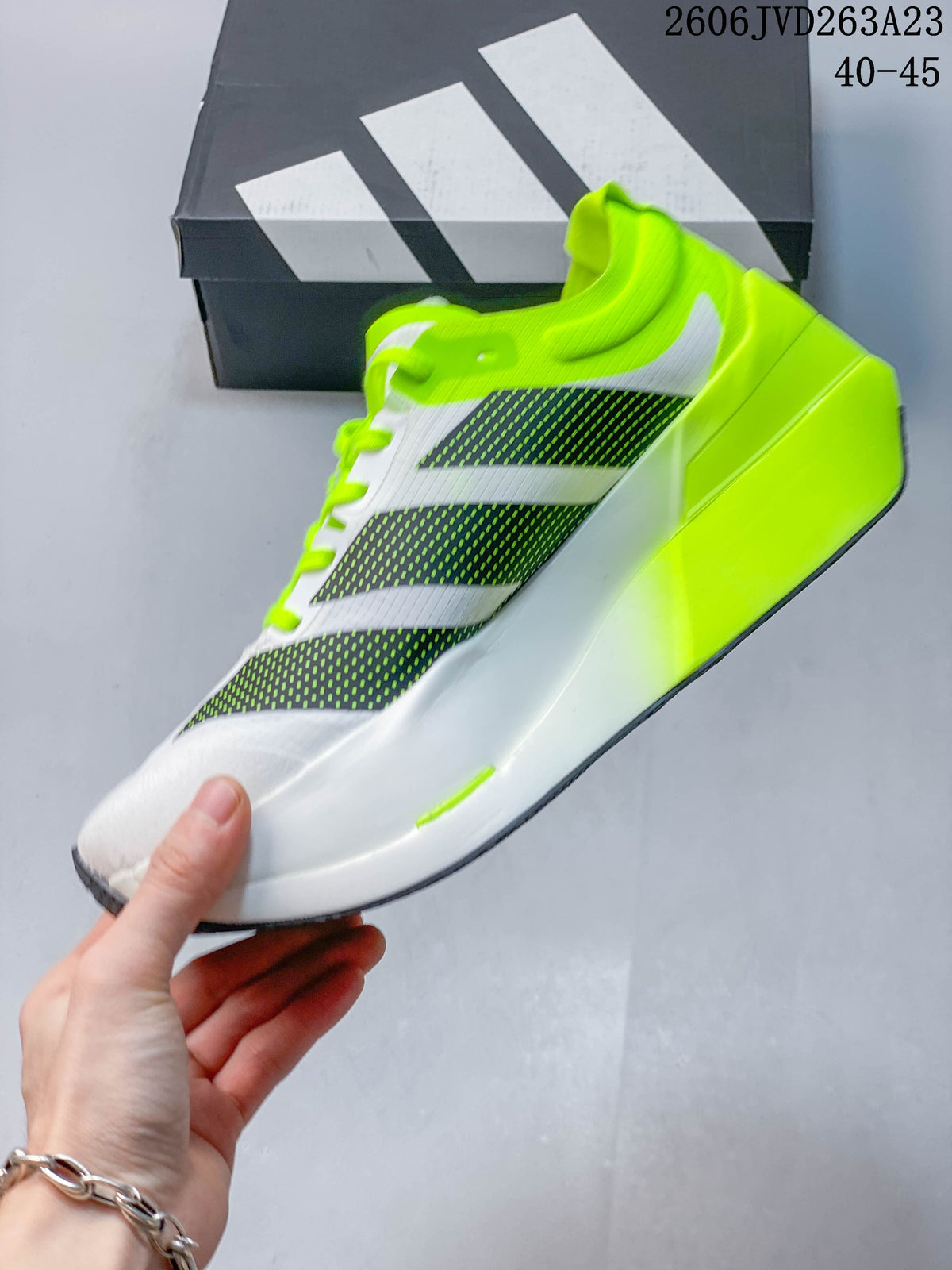 Side view of a white running shoe with dark patterned stripes and a neon-yellow collar and heel.