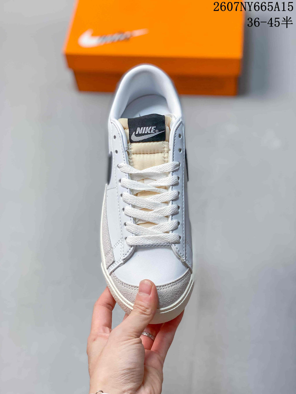 Top view of the white lace-up sneaker with a black Nike tongue label and gray toe panel.