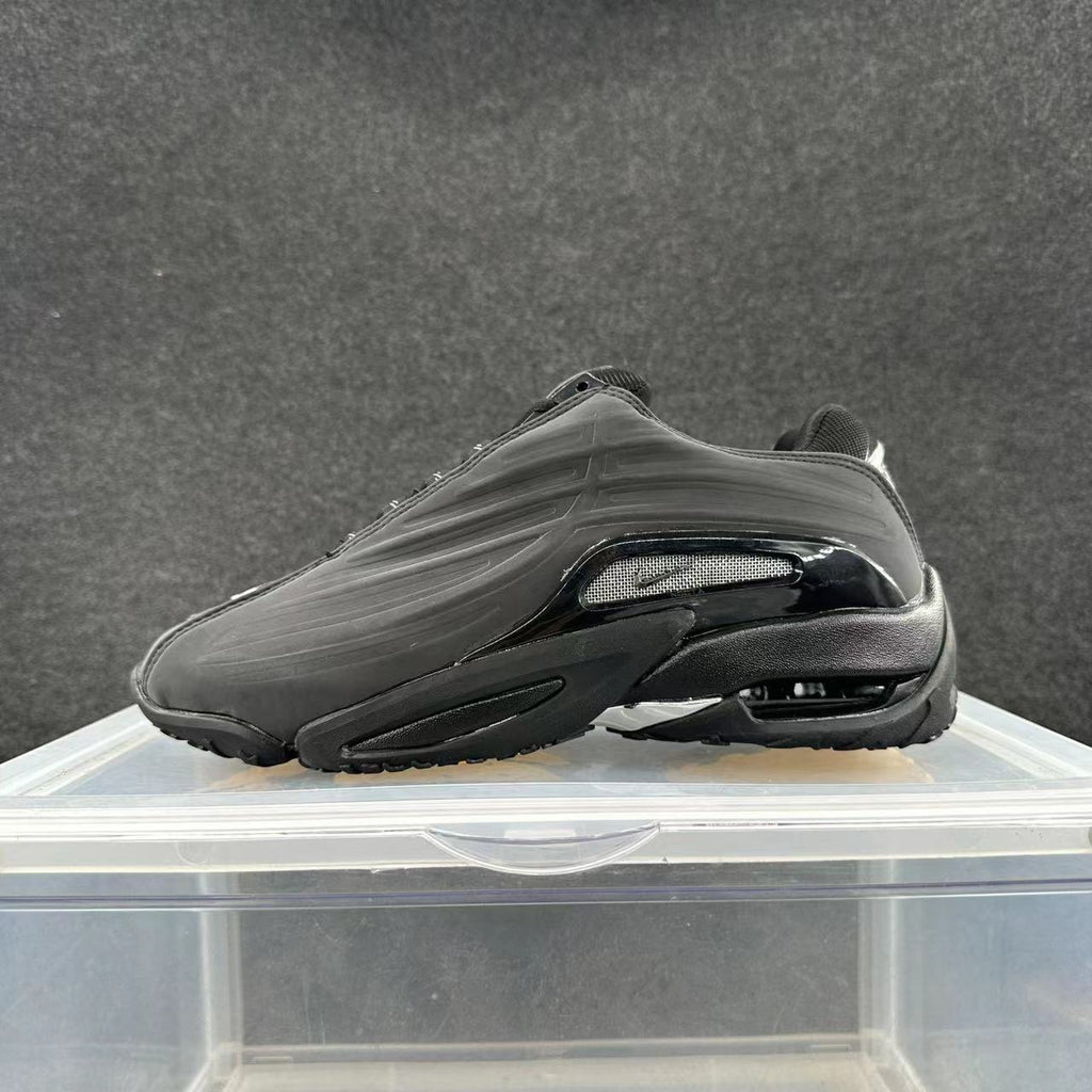 Black low-top sneaker with sculpted side panels and contrasting side accent