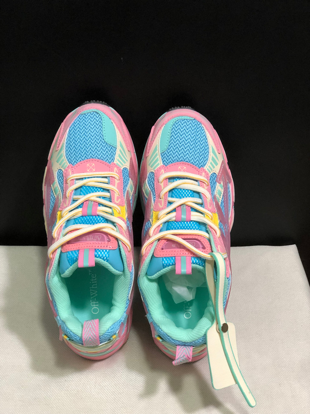 Top view showing the round toes, cream laces, pink overlays and blue mesh panels.