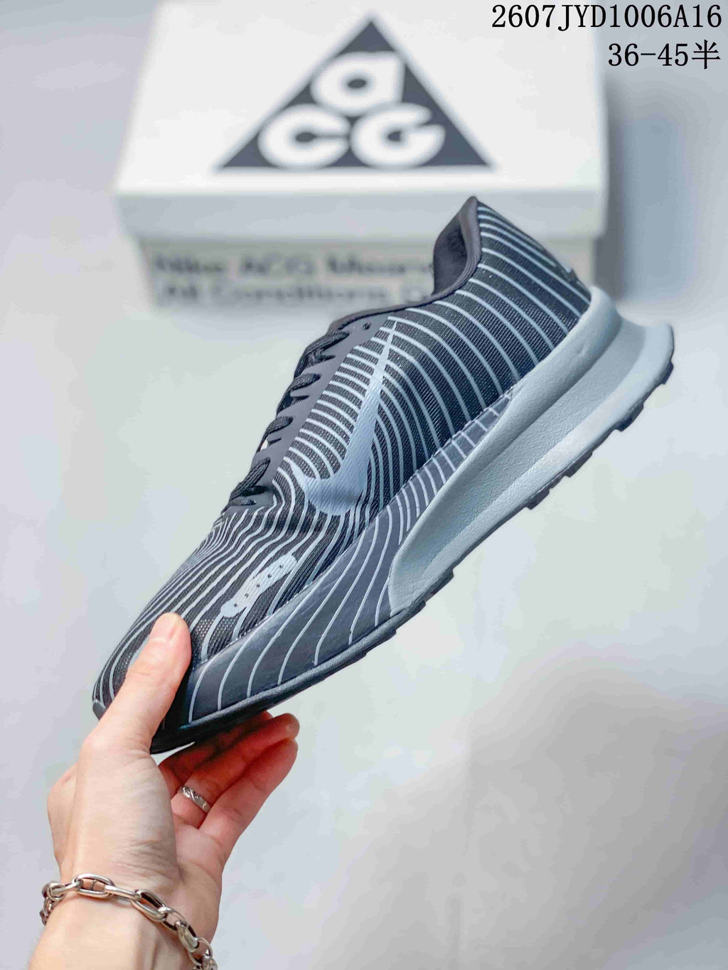 Side profile showing the striped upper, gray midsole, and rugged outsole.