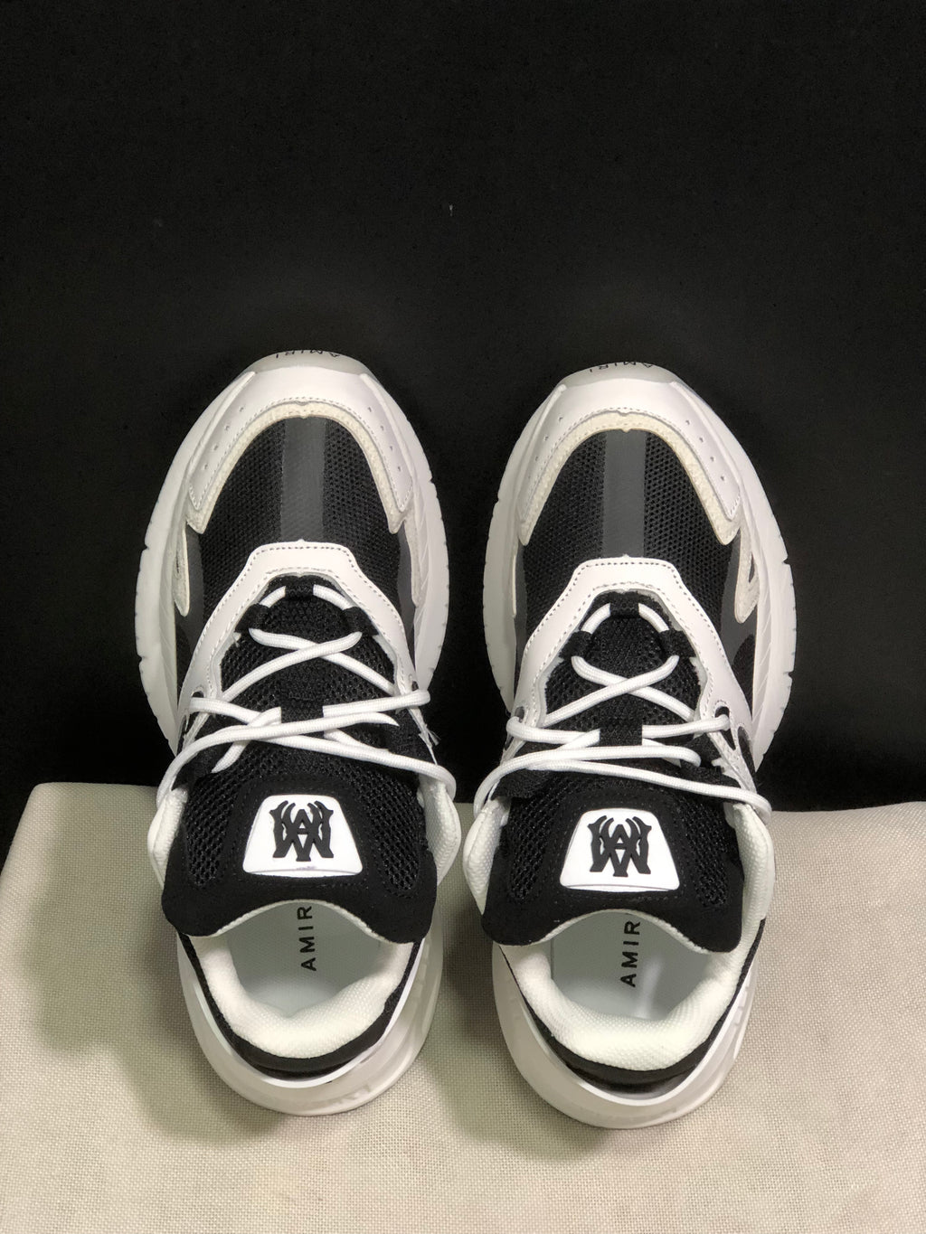 Top view showing the black mesh tongues, white laces, padded collars and branded insoles.