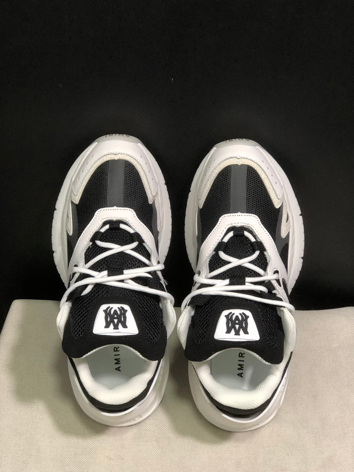 Top view showing the black mesh tongues, white laces, padded collars and branded insoles.
