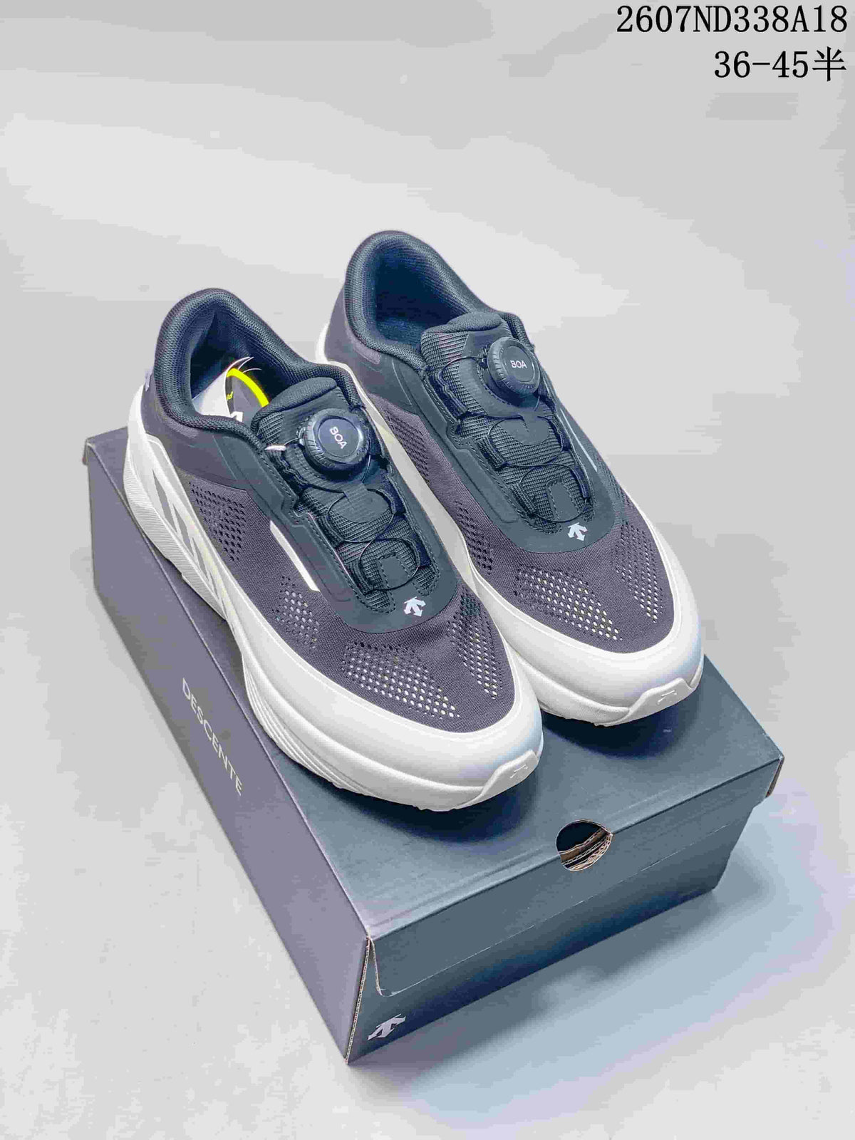 Descente D.F. Wire 3.0 sneakers shown from a front three-quarter angle on their shoebox, with the dark navy upper, white sole, and BOA dial visible. Overlay text shows style code 2607ND338A18 and size range 36–45.5.