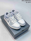 Pair of white and blue-gray Jordan 1 Low sneakers shown on a shoebox.