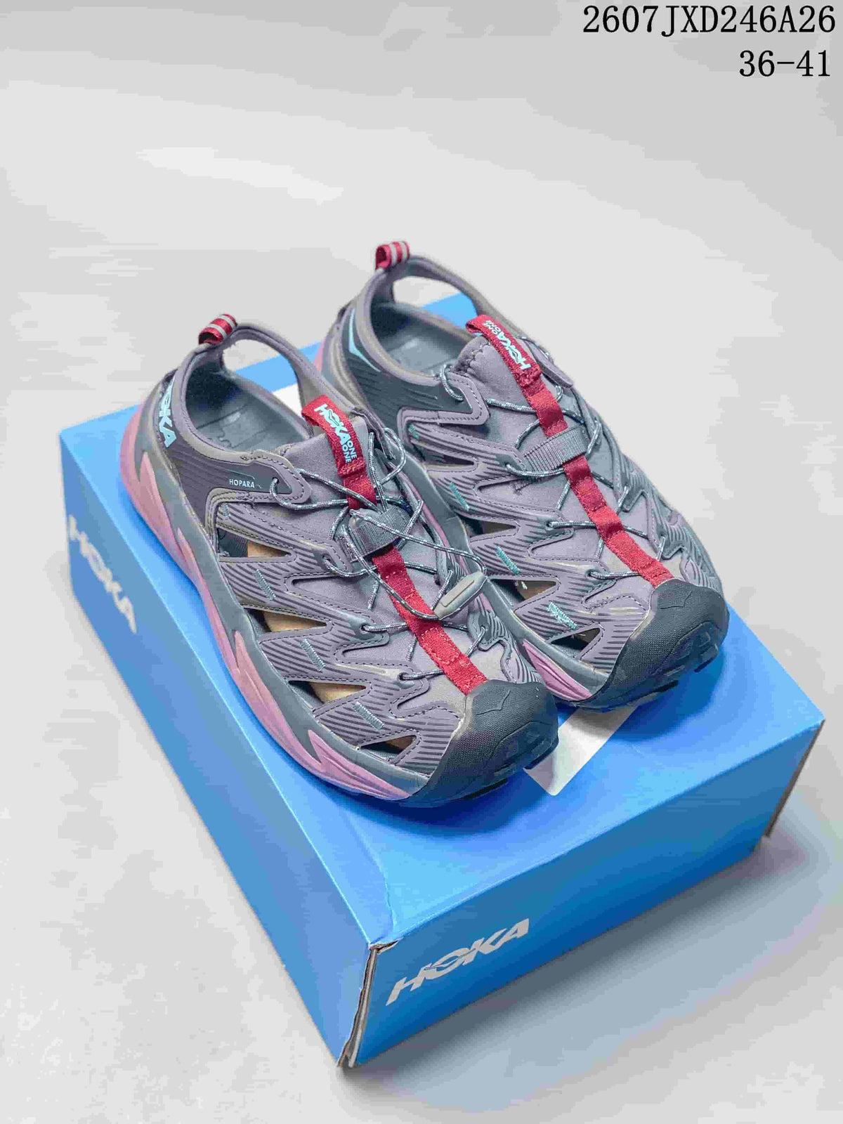 Pair of gray and pink HOKA Hopara sandals displayed on a blue shoebox.