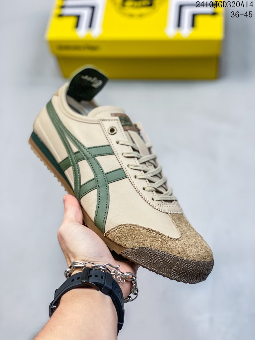 Close angled side view of the sneaker highlighting the green side stripes, cream upper, brown toe overlay and textured outsole.