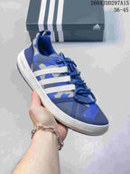 Angled side view of the blue and white adidas shoe showing the three side stripes, lace fastening, white midsole and heel marking.