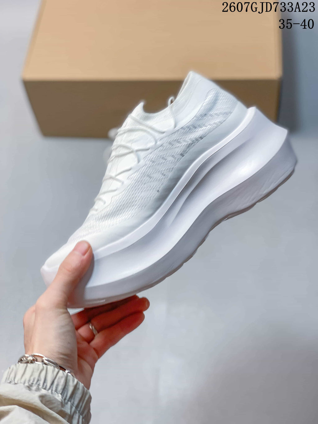 Side profile of the white low-top sneaker with a textile-style upper and platform sole.