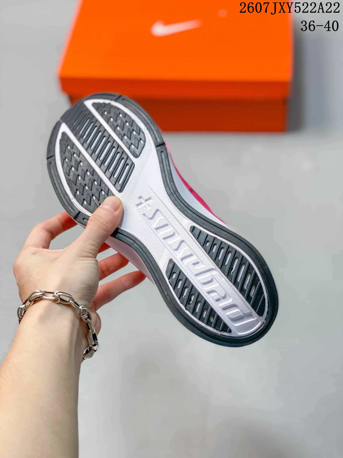 Underside view showing the black-and-white patterned outsole and raised central branding.