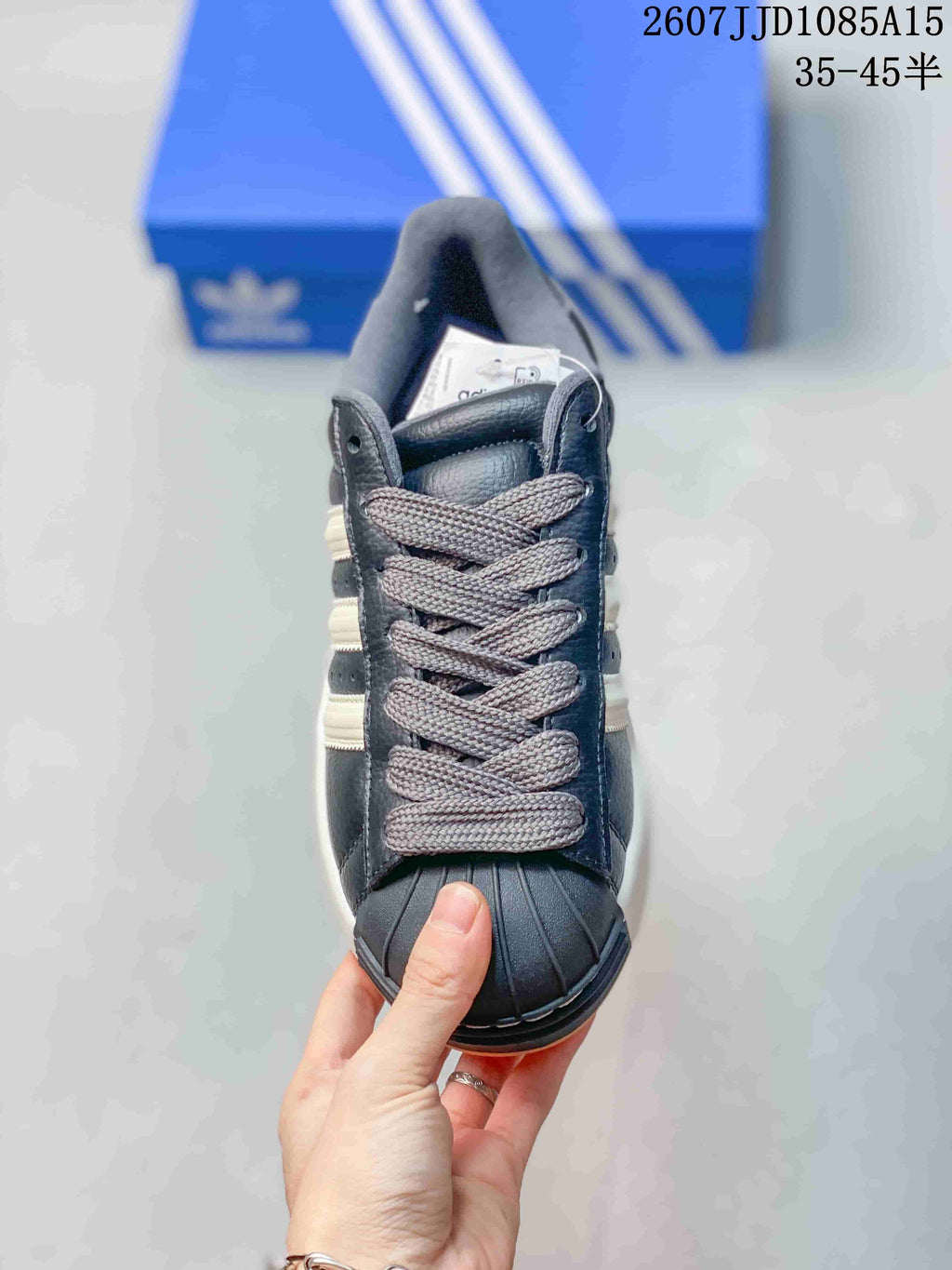 Top view of the sneaker showing gray laces, black shell-style toe cap, and light side stripes.