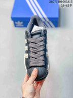 Top view of the sneaker showing gray laces, black shell-style toe cap, and light side stripes.