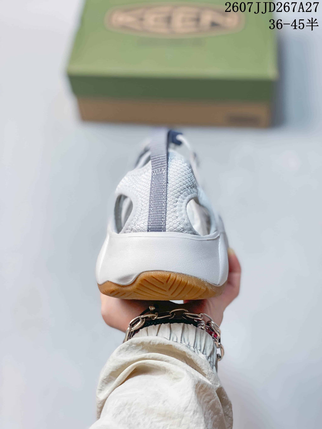 Rear view of the white and gray KEEN sandal showing the heel pull tab, open heel area, and gum-colored outsole.