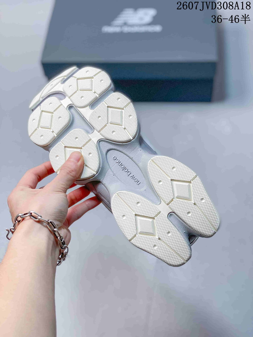 Underside view of a New Balance 9060 sneaker showing the segmented white and gray outsole pattern.