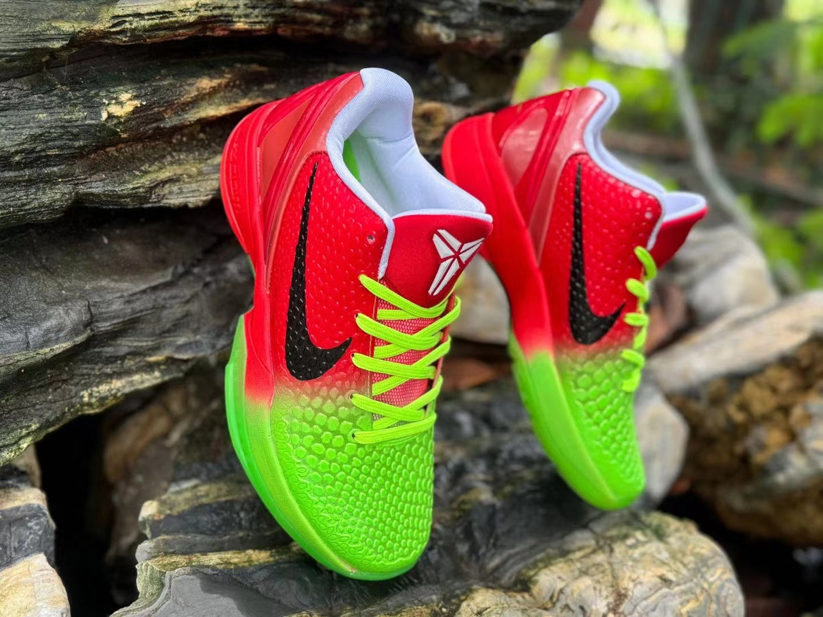 Angled view of the red and green Kobe 6 shoes with black Swooshes and white tongue logos