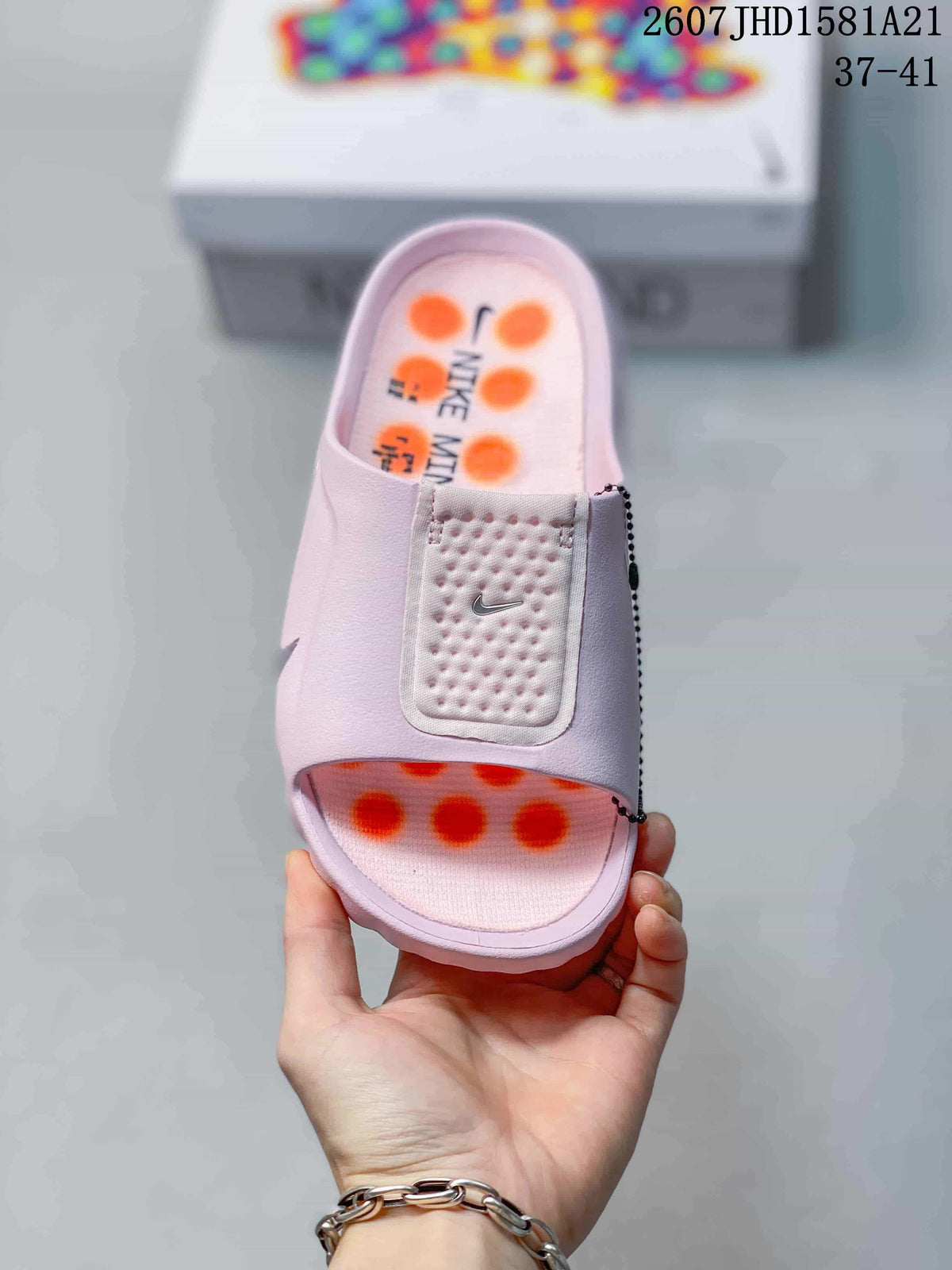Top view of a light pink mule slide with a wide textured strap and orange footbed accents.