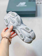Close-up of the grey sneaker outsole showing its sculpted tread and segmented cushioning areas.