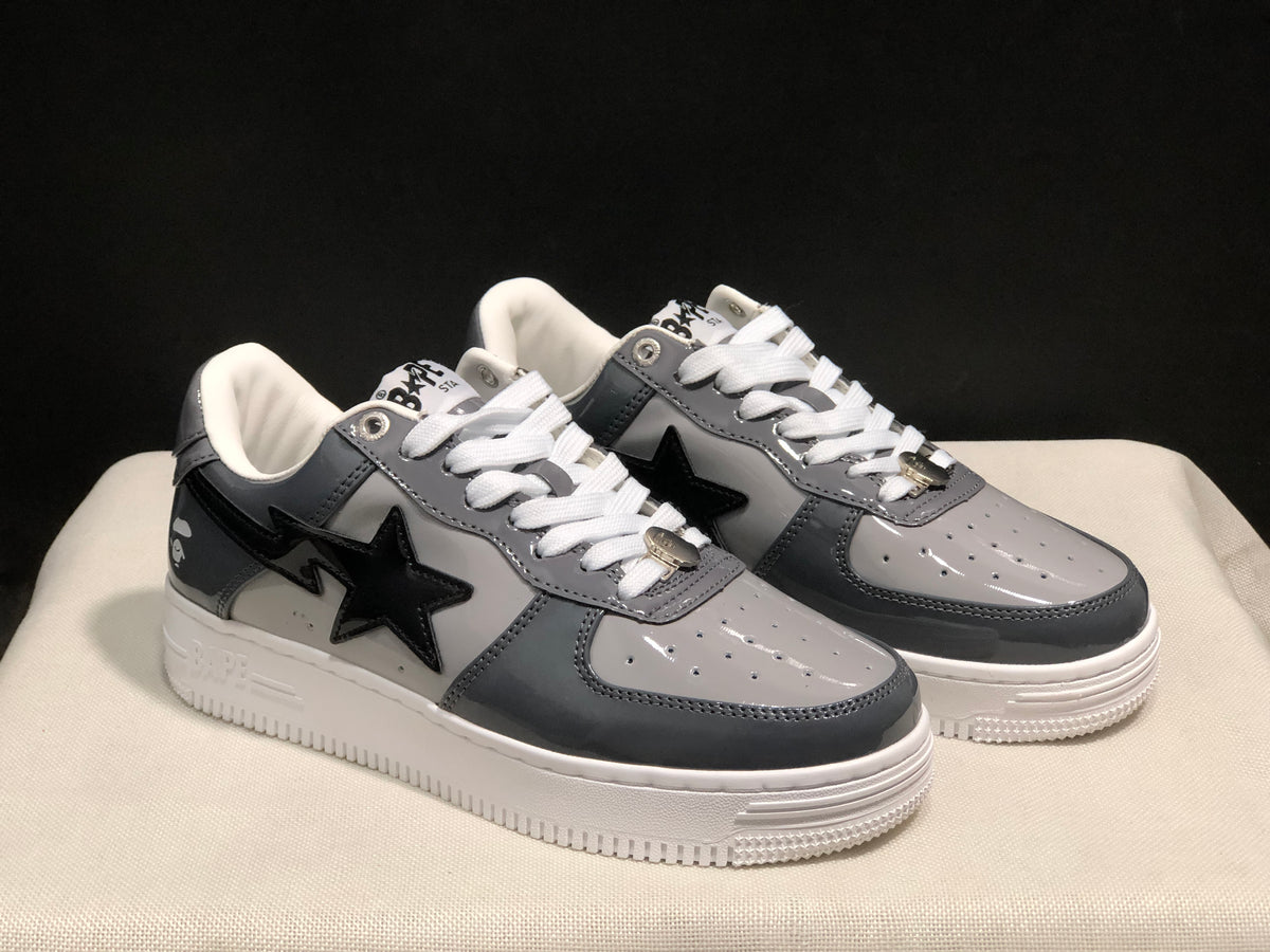 Three-quarter view of the pair with dark gray panels, black star details, and white soles.