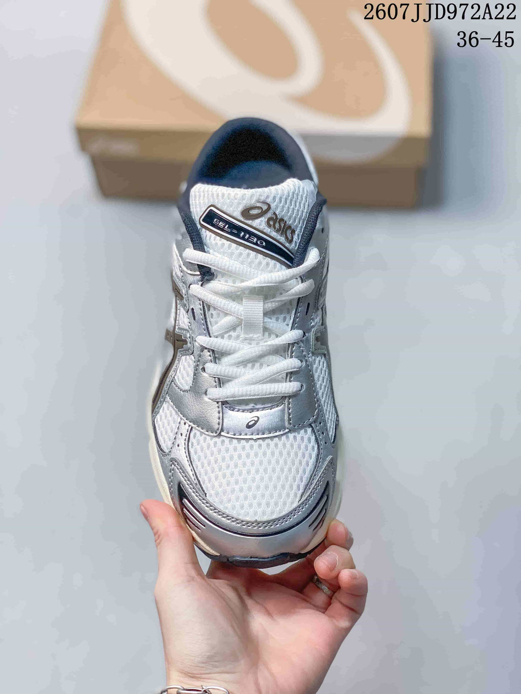 Top view of a white and silver lace-up sneaker with mesh detailing and a tongue marked Gel-1130; image text shows style code JJD972A22 and size range 36–45.