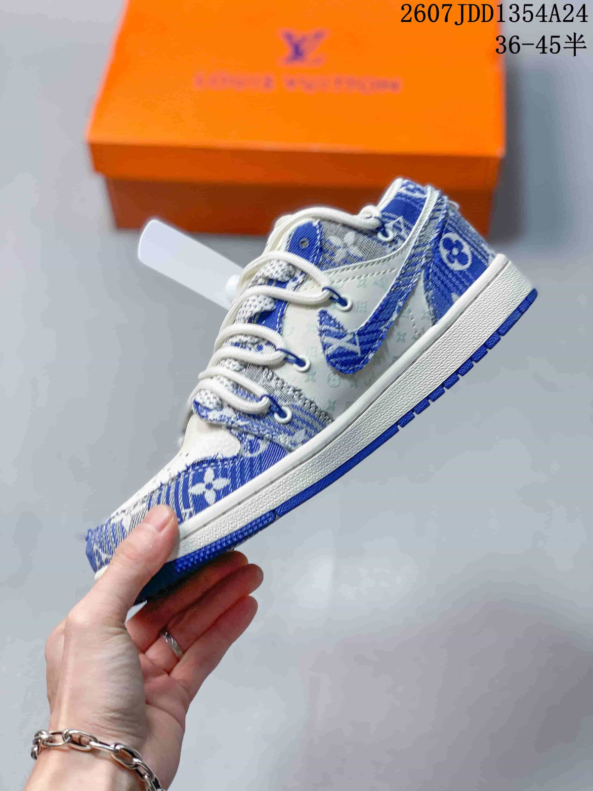 Side view of a blue and white Nike Dunk Low Retro sneaker held in front of an orange shoebox, with style code JDD1354A24 and size range 36–45 visible at the top.
