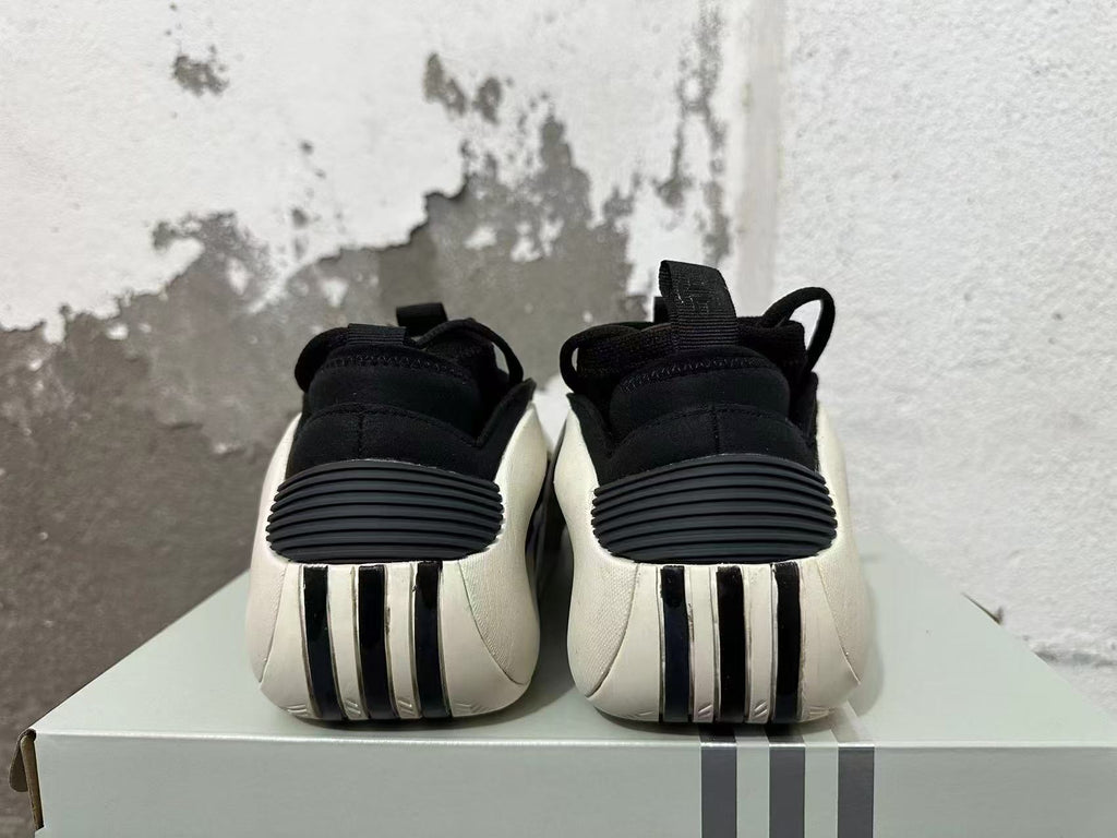 Rear view of black sneakers with white heel panels and ribbed details