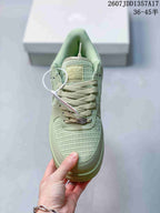 Top view of the pale green sneaker showing woven toe panels, tonal laces and a decorative lace accessory.