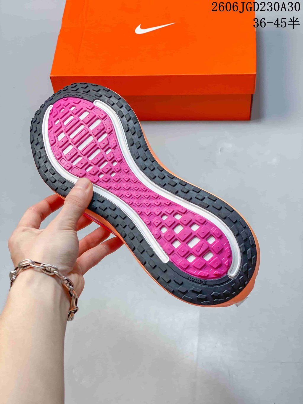 Close-up of the shoe outsole showing a black tread around a bright pink central section.