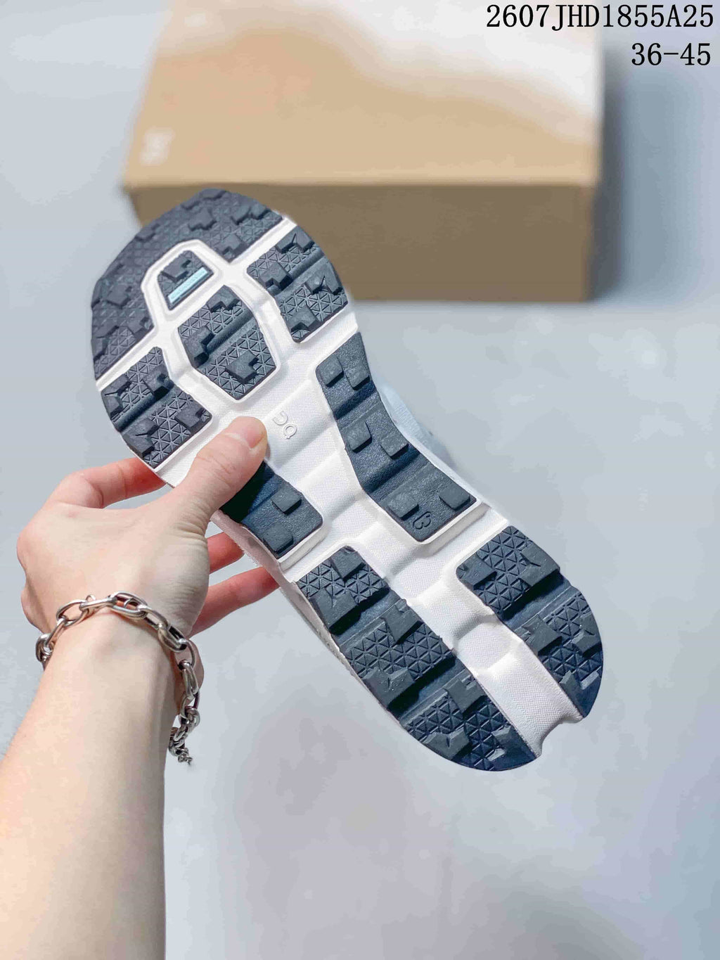 Underside view of the sneaker showing a dark segmented outsole with textured tread blocks; overlay text shows style code 2607 JHD1855A25 and size range 36-45.