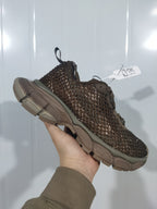 Side and heel view of the brown textured sneaker showing the layered upper, rear pull loop, and chunky tonal outsole.
