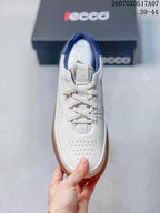 Top view of the white sneaker showing the lace-up closure, perforated toe, navy collar lining, and padded tongue.