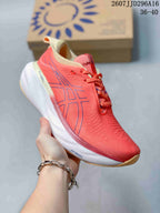 Angled side view of the coral pink ASICS GEL-Nimbus 25 shoe showing the blue logo, white midsole and visible PureGEL and FF BLAST+ markings.